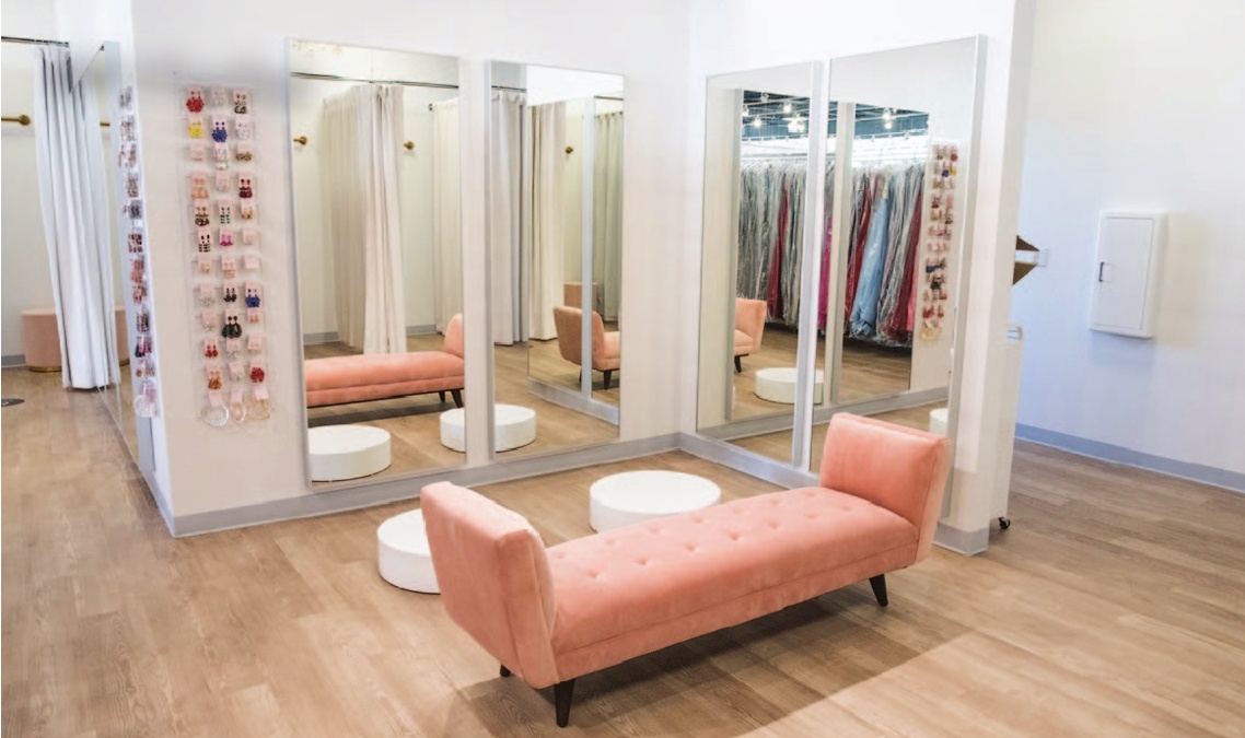 a room with a pink couch and mirrors