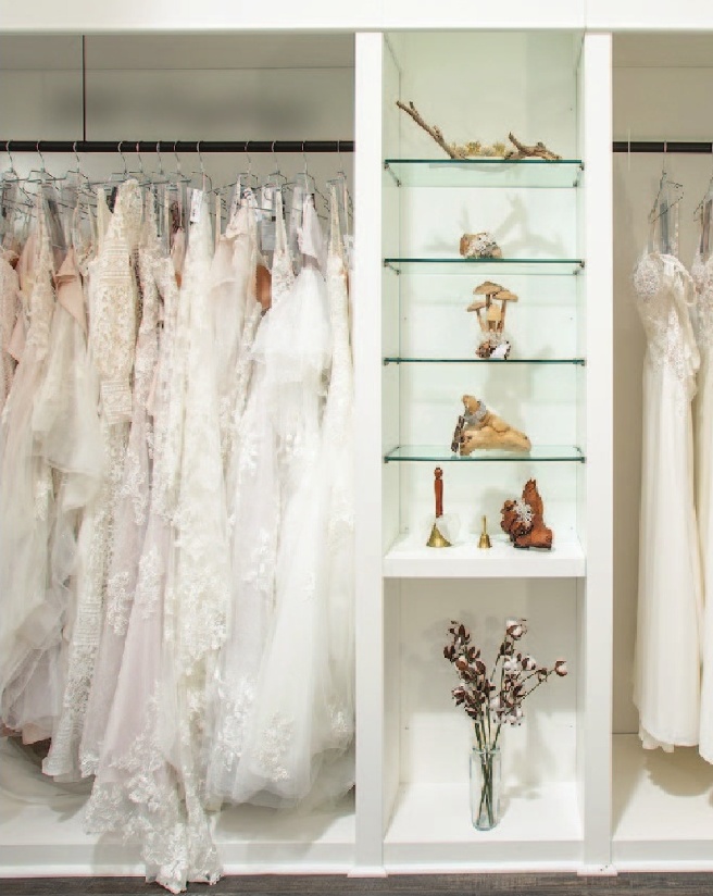a white shelves with dresses and flowers