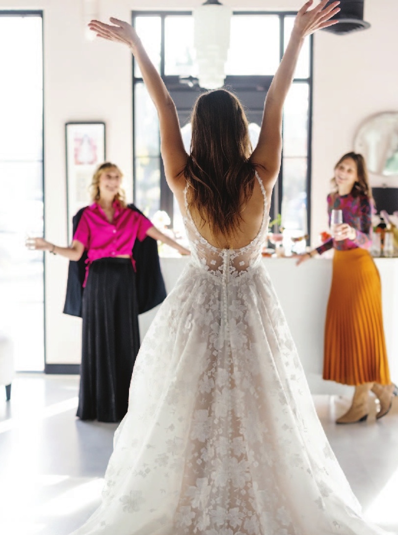 a woman in a white dress with her arms up