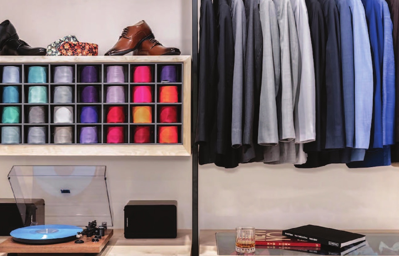 a clothes rack with shoes and a glass of whiskey