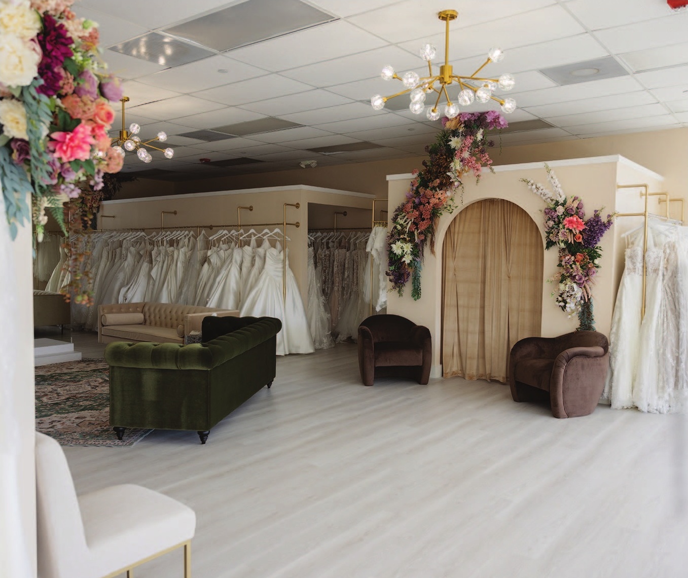 a room with a variety of dresses and a chandelier