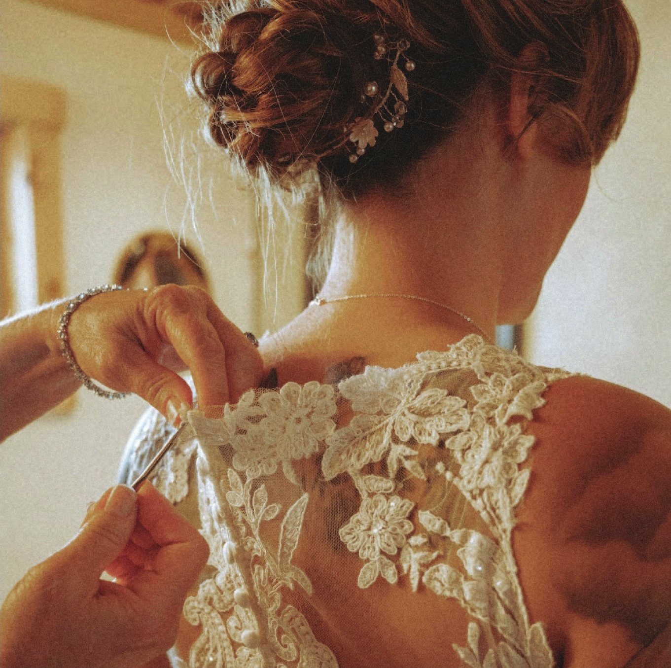 a woman getting dressed in a wedding dress